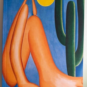 May include: A lined journal featuring the artwork "Abaporu" by Tarsila do Amaral. The cover art depicts a stylized orange figure with a large foot, a cactus, and a yellow sun against a blue background. The title and artist's name are printed at the bottom.