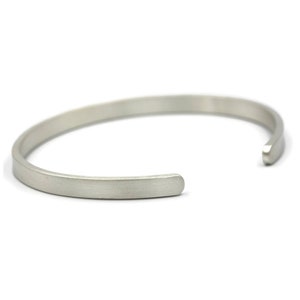 Puede incluir: Una pulsera de pu&ntilde;o plateada con un acabado mate. El dise&ntilde;o abierto permite un f&aacute;cil uso. La pulsera es un accesorio simple y minimalista.