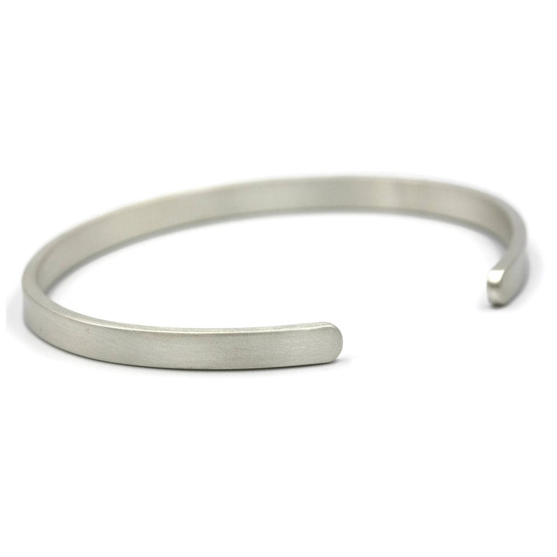 Puede incluir: Una pulsera de pu&ntilde;o plateada con un acabado mate. El dise&ntilde;o abierto permite un f&aacute;cil uso. La pulsera es un accesorio simple y minimalista.