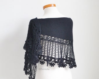 May include: Black crochet shawl with a delicate lace pattern and fringe. The shawl is draped over a white mannequin.