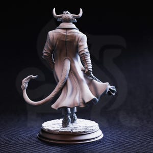Peut inclure: Figurine d&eacute;taill&eacute;e d'un personnage de minotaure, vue de dos. La figurine porte un long manteau et a une queue. Le minotaure se tient sur une base circulaire avec un motif de pav&eacute;s. La figurine a des cornes et une texture semblable &agrave; de la fourrure.