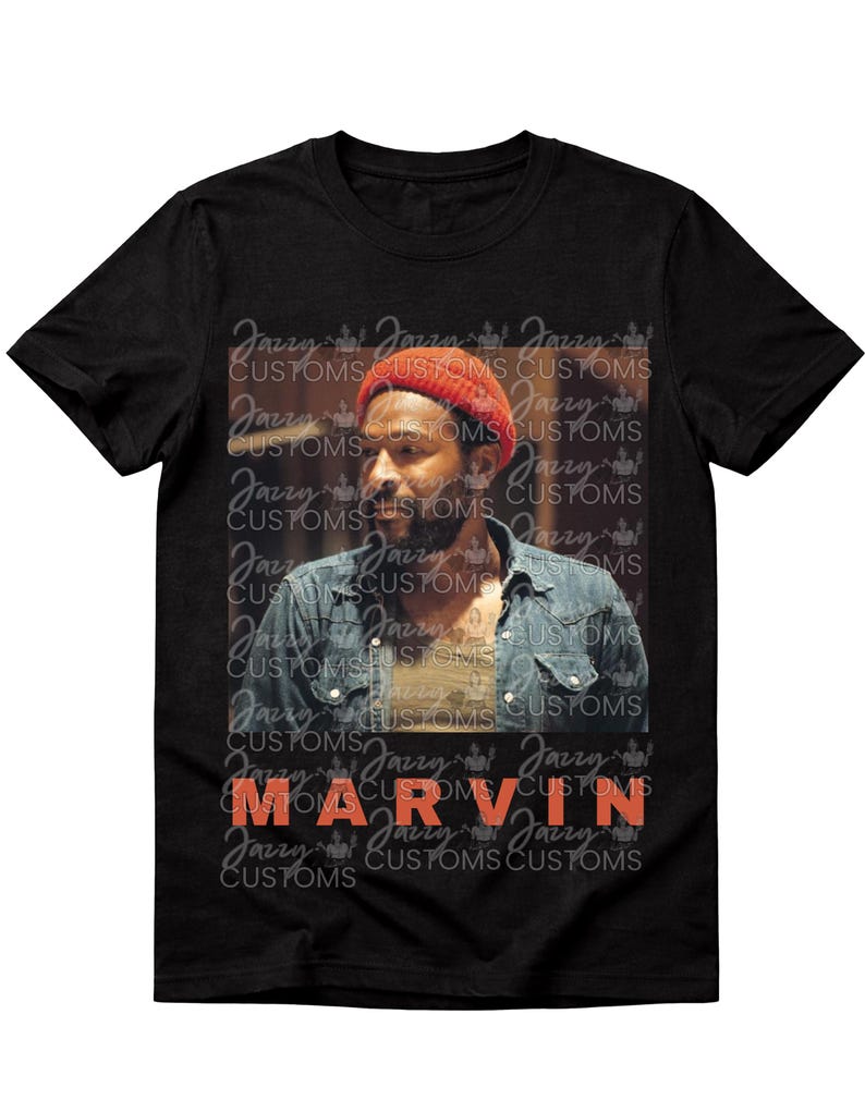 May include: Black t-shirt featuring a portrait of a man wearing a red beanie and denim shirt. The name "MARVIN" is printed in orange block letters. The background has a repeating pattern of "Jazzy Customs".