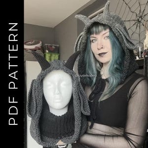May include: A gray crochet hood with horns, displayed on a mannequin head and worn by a person. The hood has a dark gray color with a textured appearance. The text "PDF PATTERN" is visible on the left side of the image.