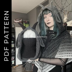 May include: A gray crochet hooded cowl with horns and ear details, and a matching face covering. The cowl is held up by a mannequin head. The image also shows a matching crochet shawl. The text "PDF PATTERN" is on the left side of the image.