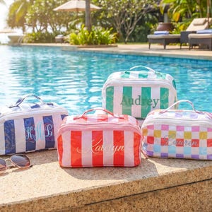 May include: Four cosmetic bags with different striped and checkered patterns. One is blue and white, one is green and white, one is red and white, and one is multi-colored. Each bag has a name printed on it.