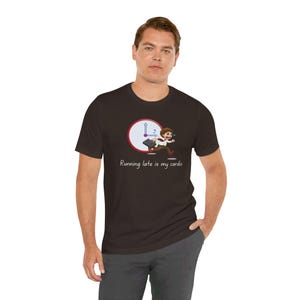 May include: A black t-shirt featuring a white clock and a cartoon man running late. The text on the shirt reads "Running late is my cardio."