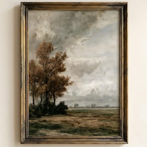 May include: A framed landscape painting featuring a group of brown trees on the left side against a cloudy, overcast sky. The foreground shows a flat, earthy field with muted green and brown tones, all enclosed in a dark, ornate gold frame.
