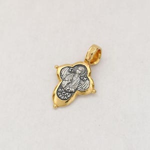 以下が含まれることがあります： 翼のある天使の宗教的なアイコンが描かれた、金と銀のペンダント。ペンダントは丸みを帯びたデザインの十字架の形をしています。アイコンは金色の縁取りで囲まれており、ギリシャ語で「&Alpha;&Rho;&Chi;&Alpha;&Gamma;&Gamma;&Epsilon;&Lambda;&Omicron;&Sigma; &Mu;&Iota;&Chi;&Alpha;&Eta;&Lambda;」という文字が書かれています。
