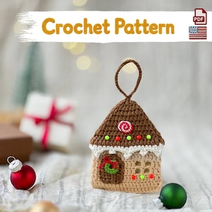 May include: A crochet pattern PDF for a gingerbread house ornament. The ornament is light brown with a dark brown roof, white frosting trim, a green wreath on the door, and small red and green beads representing candy decorations.