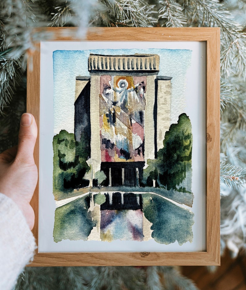 May include: Watercolor painting of a building with a large stained glass window depicting a religious scene. The building is surrounded by trees and a reflecting pool.