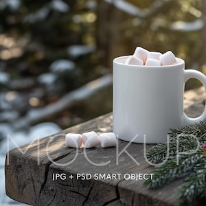 May include: A white ceramic mug filled with marshmallows sits on a rustic wooden surface with a sprig of evergreen and red berries. The mug is a blank canvas for customization.