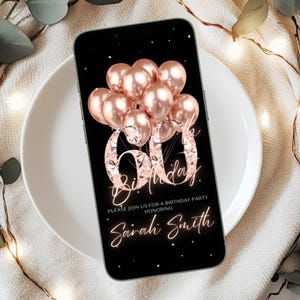 May include: A smartphone displays a 60th birthday invitation. The black screen features rose gold balloons, the number 60 in a diamond-like font, and the words "Birthday" and "Sarah Smith" in a script font. The phone rests on a white plate.