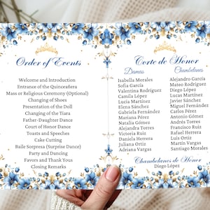 May include: A white card with blue and gold floral borders and a gold crown. The card lists the order of events for a Quinceañera celebration, including the entrance of the Quinceañera, changing of shoes, presentation of the doll, and more. It also lists the names of the Court of Honor, including the damas and chambelanes.