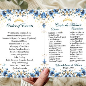 May include: A white card with blue and gold floral borders and gold lettering. The card lists the order of events for a Quinceañera celebration, including the entrance of the Quinceañera, changing of shoes, presentation of the doll, and more. The card also lists the names of the Court of Honor, including the Damas and Chambelanes.