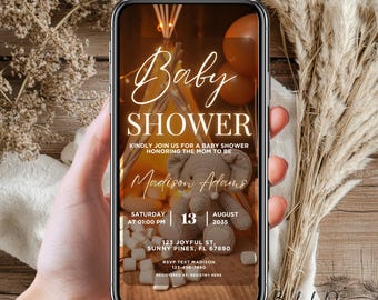 May include: A digital invitation for a baby shower with a brown and white elephant toy, a teepee, and the text "Baby Shower" in gold script. The invitation includes the name "Madison Adams", the date "Saturday, August 13, 2035", the time "01:00 PM", the address "123 Joyful St, Sunny Pines, FL 67890", and the RSVP information.
