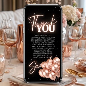 May include: A smartphone displays a digital invitation with the words "Thank You" in elegant script. The invitation, set against a black background, includes a message and the name "Sarah", along with rose gold balloons. The image is set on a table with rose gold decor.