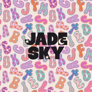 May include: A repeating pattern of colorful, stylized alphabet letters in shades of orange, pink, purple, and teal against a cream background. The letters feature various textures like stripes, checks, stars, and flowers. The black text JADE SKY is centered.