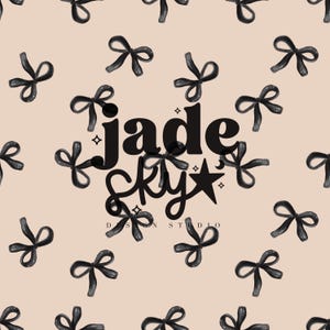 以下が含まれることがあります： 明るいピーチ色の背景に、黒いリボンのパターン。中央には「jade sky」の文字と星とひし形。テキスト「DESIGN STUDIO」が下にあります。