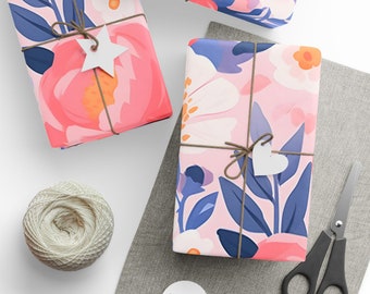 May include: Three gift boxes wrapped in pink and blue floral patterned paper with white accents. The boxes are tied with twine and decorated with white paper stars and hearts.