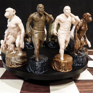 May include: A set of 3D printed chess pieces featuring prehistoric human and primate figures. The pieces are rendered in shades of brown, cream, and black, each standing on a circular base marked with letters like Q and K, arranged on a rotating display.