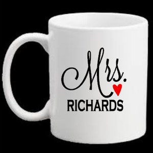 Puede incluir: Taza de cer&aacute;mica blanca con un "Mrs." en cursiva negra y un coraz&oacute;n rojo seguido del apellido "RICHARDS" en negro.