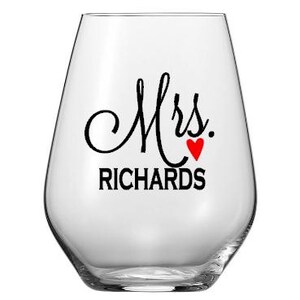 Puede incluir: Una copa de vino sin tallo de vidrio transparente con el texto "Mrs. RICHARDS" y un coraz&oacute;n rojo.