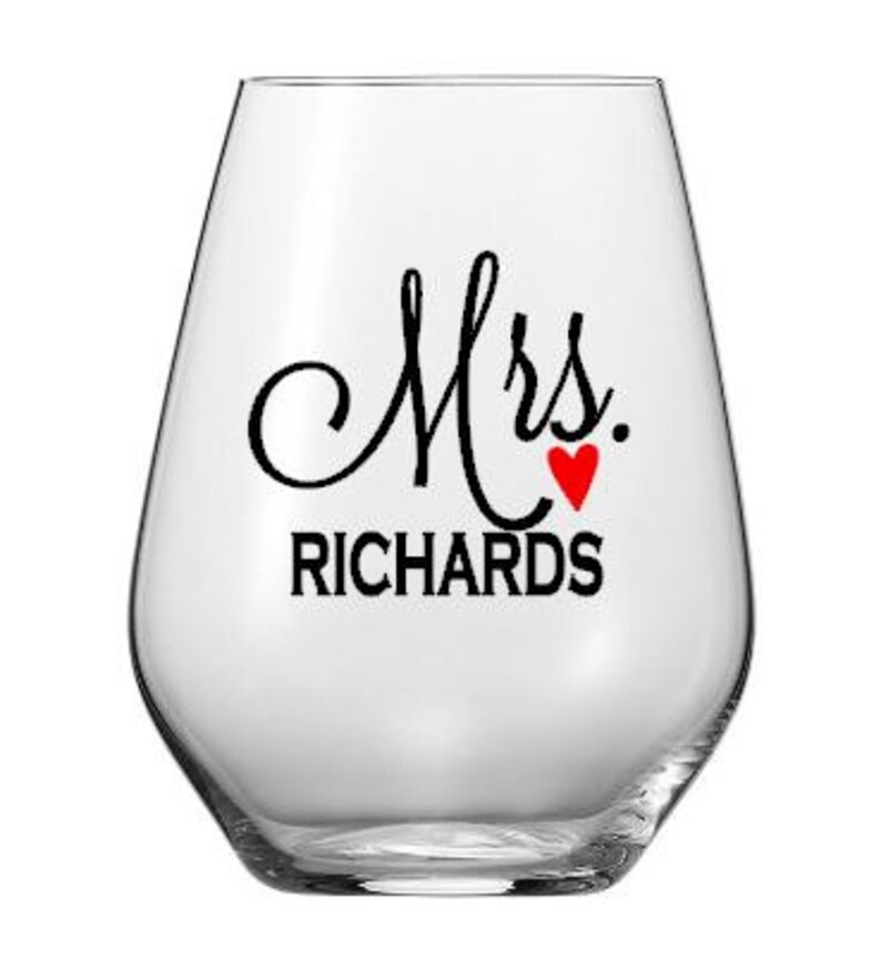 Puede incluir: Una copa de vino sin tallo de vidrio transparente con el texto "Mrs. RICHARDS" y un coraz&oacute;n rojo.