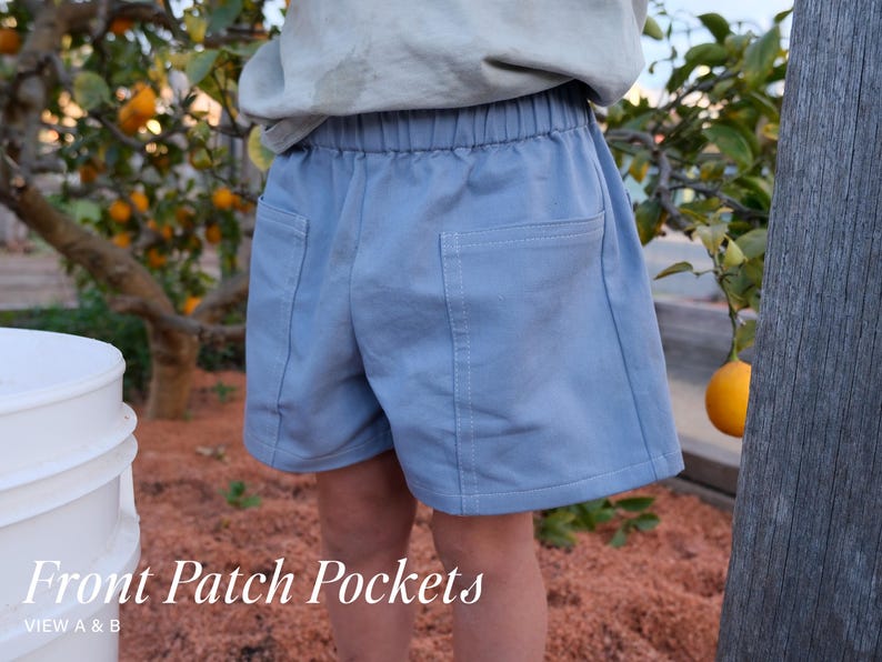 May include: Light blue shorts featuring an elastic waistband and two large square patch pockets on the front. The garment includes visible stitching details along the pocket edges. The text Front Patch Pockets VIEW A & B is displayed.
