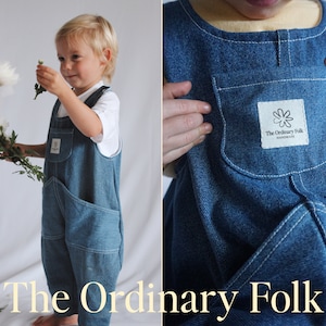 以下が含まれることがあります： 「The Ordinary Folk Handmade」と書いてあるパッチがついた、青いデニムのオーバーオールを着た子供。