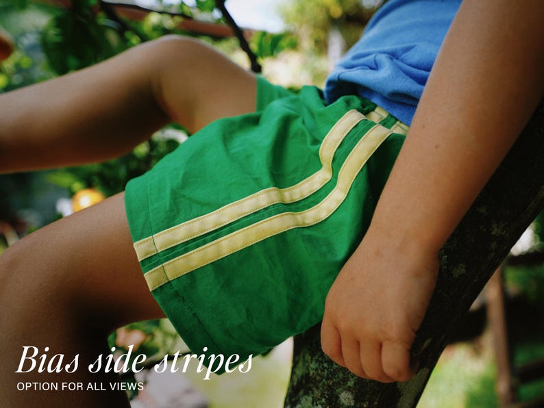 May include: Bright green athletic shorts featuring two parallel light yellow stripes running down the side. The shorts are paired with a plain blue t-shirt. The text Bias side stripes OPTION FOR ALL VIEWS is printed in white at the bottom.