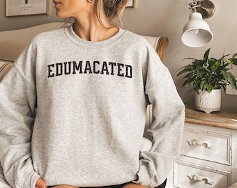 May include: A gray sweatshirt with the text "EDUMACATED" printed in black on the front.