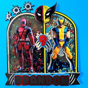 May include: A black and red cake topper featuring Deadpool and Wolverine characters. The cake topper is decorated with glitter and a red number 9. The cake topper also includes the name "BRANDON" in red letters.