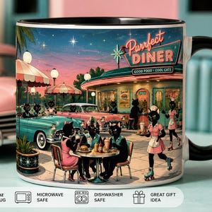 May include: A ceramic mug with a black handle and rim featuring a colorful illustration of a 1950s-style diner named Purrfect Diner with black cats as patrons and staff. The scene includes vintage cars, outdoor seating, and a roller-skating server.