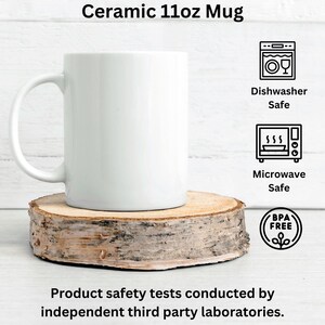 May include: A white ceramic 11oz mug with a handle, placed on a wooden slice. The mug is labelled as dishwasher and microwave safe, and BPA free. The text at the top says "Ceramic 11oz Mug".