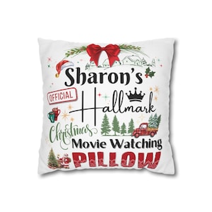 Könnte beinhalten: Weißes quadratisches Kissen mit festlichem Weihnachtsdesign. Das Kissen zeigt den Text "Sharon's Hallmark Christmas Movie Watching Pillow" mit einer roten Schleife, einem Weihnachtsmannhut und einem roten LKW mit einem Weihnachtsbaum.