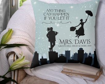 May include: A blue throw pillow with a silhouette of a man and woman against a cityscape. The text "Anything can happen if you let it" and "Mrs. Davis Green Hill High School - 2025" is printed on the pillow.