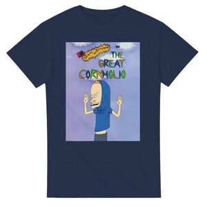 May include: A navy blue t-shirt with a graphic of the cartoon character Cornholio from the show Beavis and Butt-head. The graphic shows Cornholio with his hood up and his arms raised in the air. The text "In The Great Cornholio" is printed above the graphic.