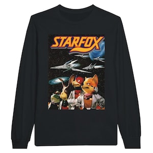 May include: Black long-sleeve t-shirt with a graphic of the Star Fox characters Fox McCloud, Falco Lombardi, and Slippy Toad. The graphic is set against a space background with stars and spaceships. The text "STARFOX" is in a yellow and orange font.