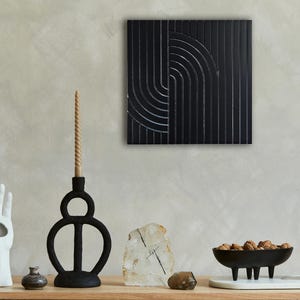 Könnte beinhalten: Schwarz-weißes abstraktes geometrisches Wandbild mit modernem Design. Die Kunst zeigt eine Reihe von vertikalen und geschwungenen Linien, die ein einzigartiges Muster erzeugen.