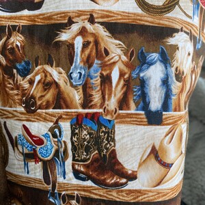 closeup of the western horse tote bag fabruc with a ranch and horses in the background.