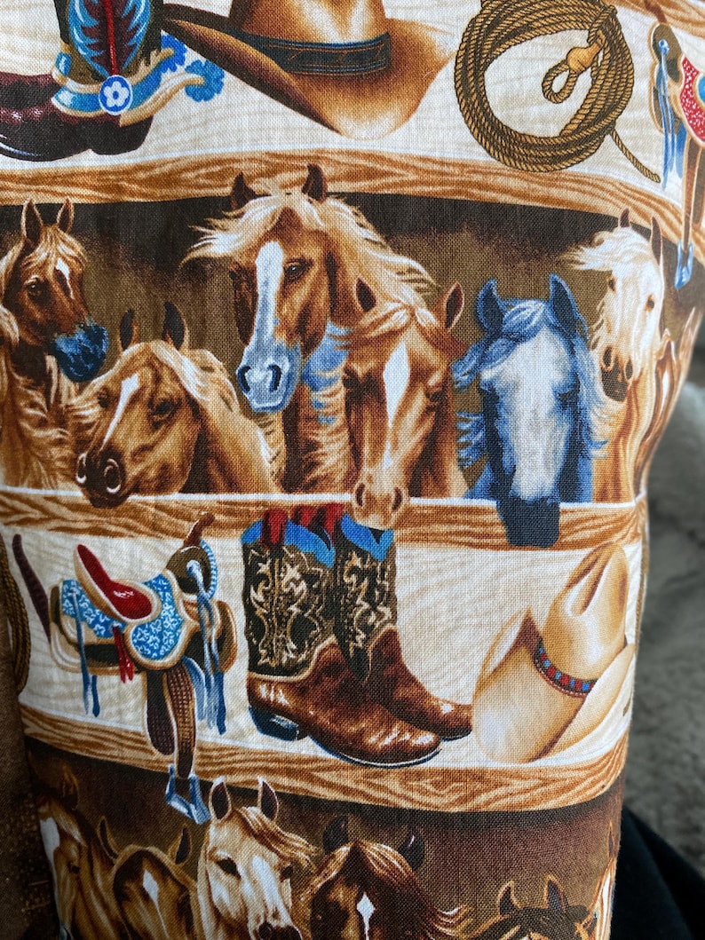 closeup of the western horse tote bag fabruc with a ranch and horses in the background.
