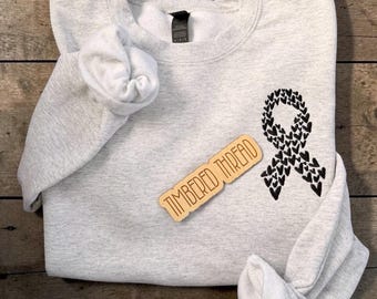 Camiseta bordada con diseño de melanoma (cáncer de piel), regalos para personas con cáncer, camiseta de concienciación sobre el cáncer de piel, lazo con forma de corazón para la concientización sobre el cáncer de melanoma (creador original).
