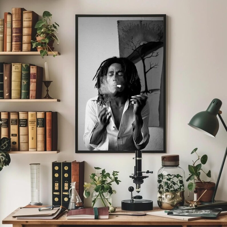 Pu&ograve; includere: Fotografia in bianco e nero di un uomo con i dreadlocks che fuma una sigaretta. L'uomo indossa una camicia bianca e guarda la fotocamera. Lo sfondo &egrave; un'immagine sfocata di un albero.