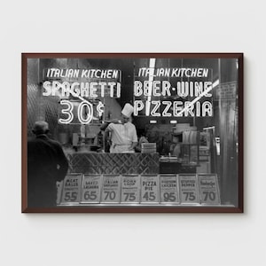 May include: A monochrome image of an Italian restaurant. Neon signs advertise "Italian Kitchen," "Spaghetti 30p," "Beer-Wine," and "Pizzeria." A chef is visible behind the counter. Menu items include spaghetti, pizza, and stuffed peppers.