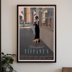 May include: A vintage movie poster for the film "Breakfast at Tiffany's" featuring Audrey Hepburn in a black dress and a cat. The poster is in a black frame and has a gray background.