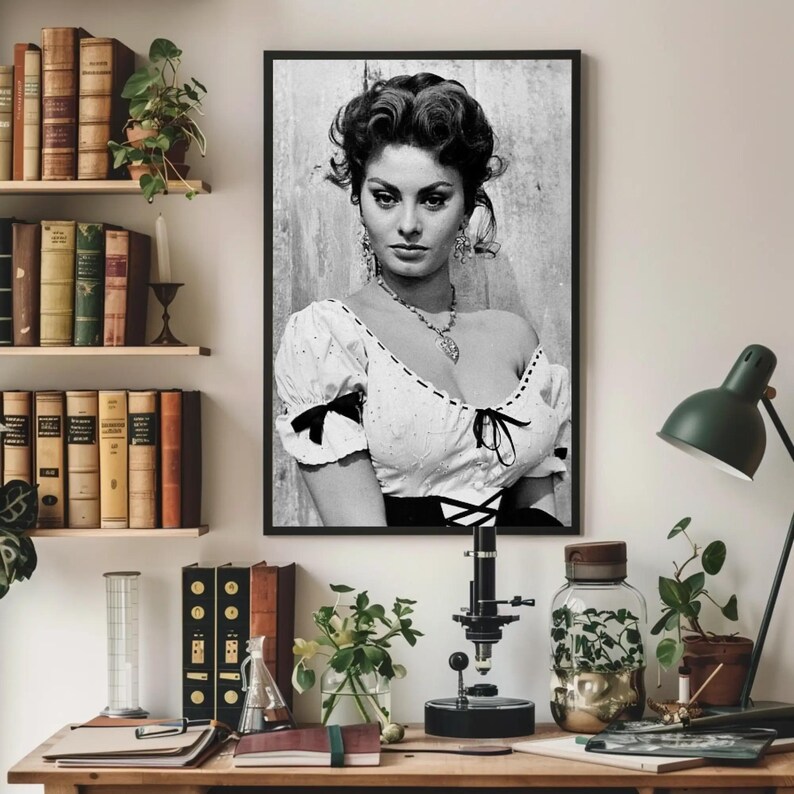 May include: Black and white portrait photograph of a woman with dark hair styled in a bouffant. She is wearing a white blouse with a lace neckline and a black bodice. The woman is looking directly at the camera with a serious expression.