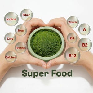 May include: Hands forming a heart shape around a green bowl filled with green powder. Bubbles with labels like 'iodine', 'iron', and 'vitamins' surround the bowl. The words 'Super Food' are displayed below the bowl.