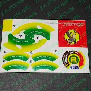 May include: A sheet of stickers featuring a green and yellow design with the text "DRANZER-S" and a red circle with the text "RIGHT SPIN" and Japanese characters.