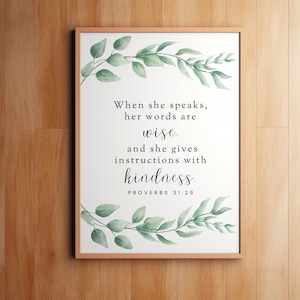 May include: A printable wall art design with a quote from Proverbs 31:26. The quote reads "When she speaks, her words are wise. And she gives instructions with kindness." The design features a watercolor illustration of green leaves.