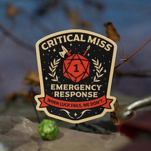 May include: A black and gold patch with the words "CRITICAL MISS EMERGENCY RESPONSE" and the text "WHEN LUCK FAILS, WE DON'T." A red die with the number 1 is in the center. Other dice and a sword are in the background.